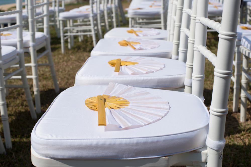 Handheld fans on wedding chairs