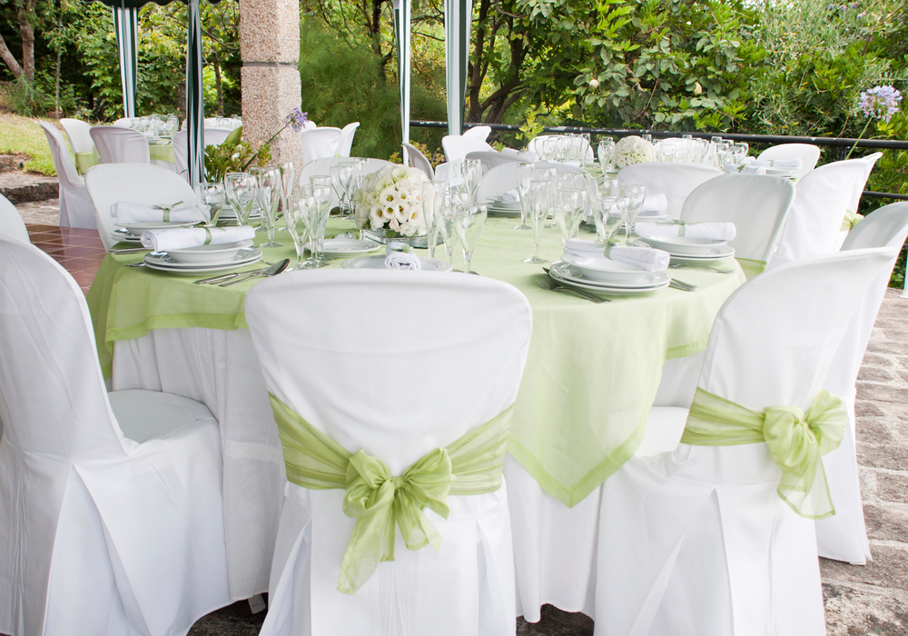 White wedding chairs with light green ribbons