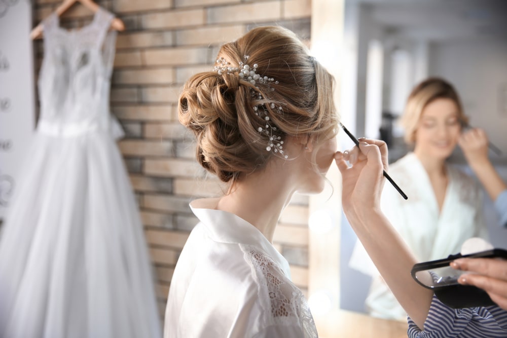 Makeup artist preparing the bride
