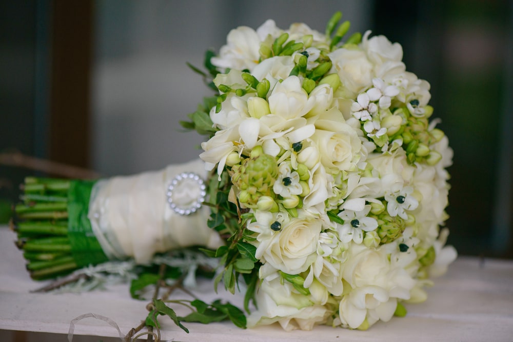 Wedding bouquet featuring ivory roses white freesias and stephanotis blossoms