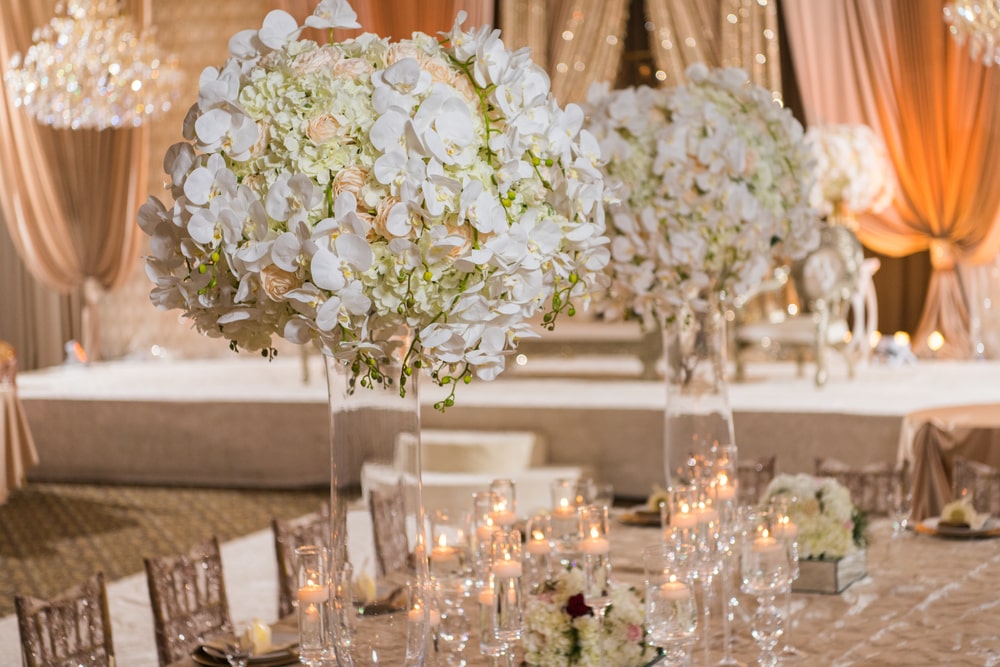 Romantic lush floral white orchids pink flowers and hydrangeas styled in centerpieces