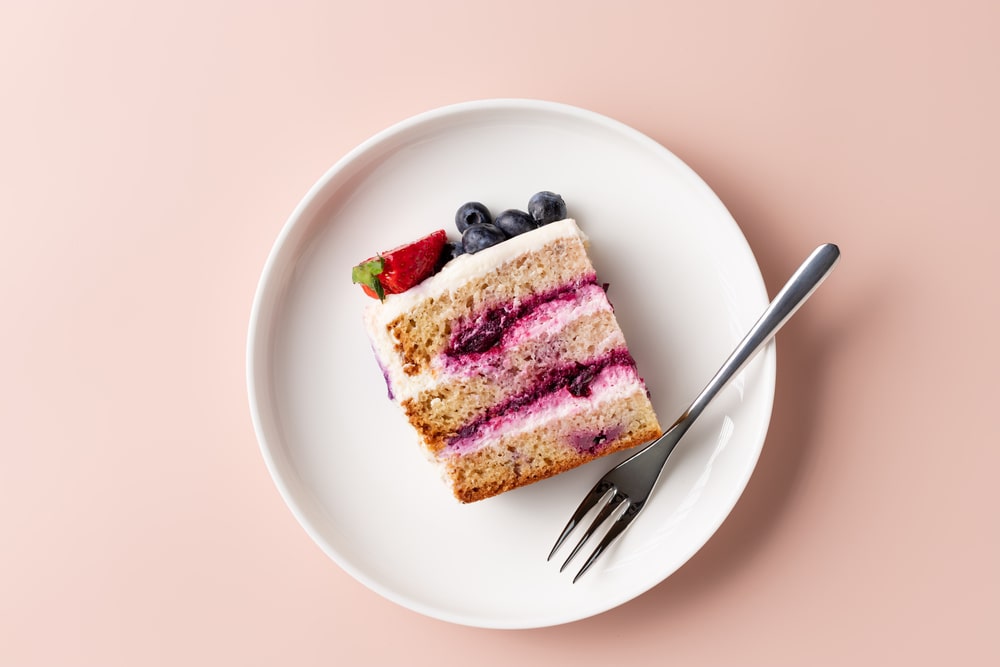 Slice of blueberry cake decorated with fresh berries