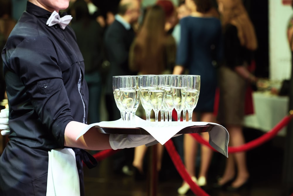 Waiter holding a tray with glasses of wine at a wedding