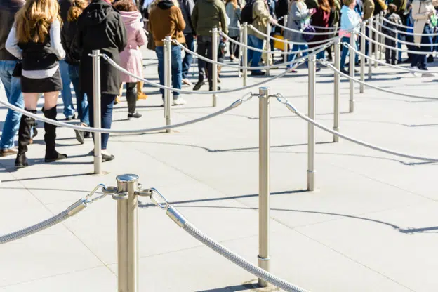 Stainless steel poles linked by grey ropes for queue control