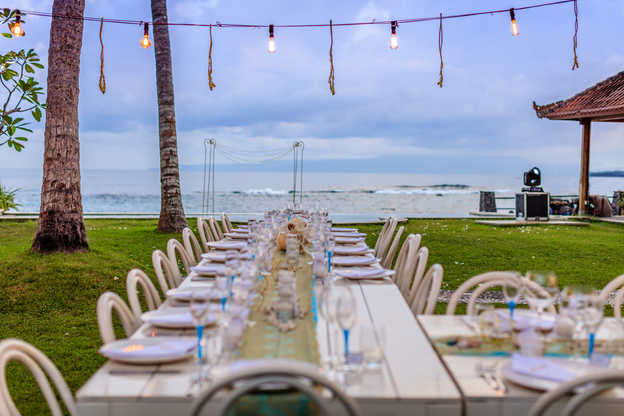 Evening set table for a white and aqua blue wedding dinner near the beach