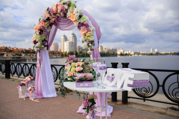 Wedding arch ceremony on the riverside with purple ribbons