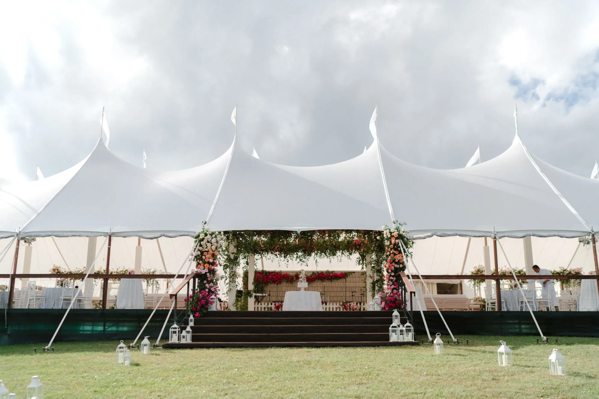 Sailcloth wedding tent with floral entrance and natural lighting