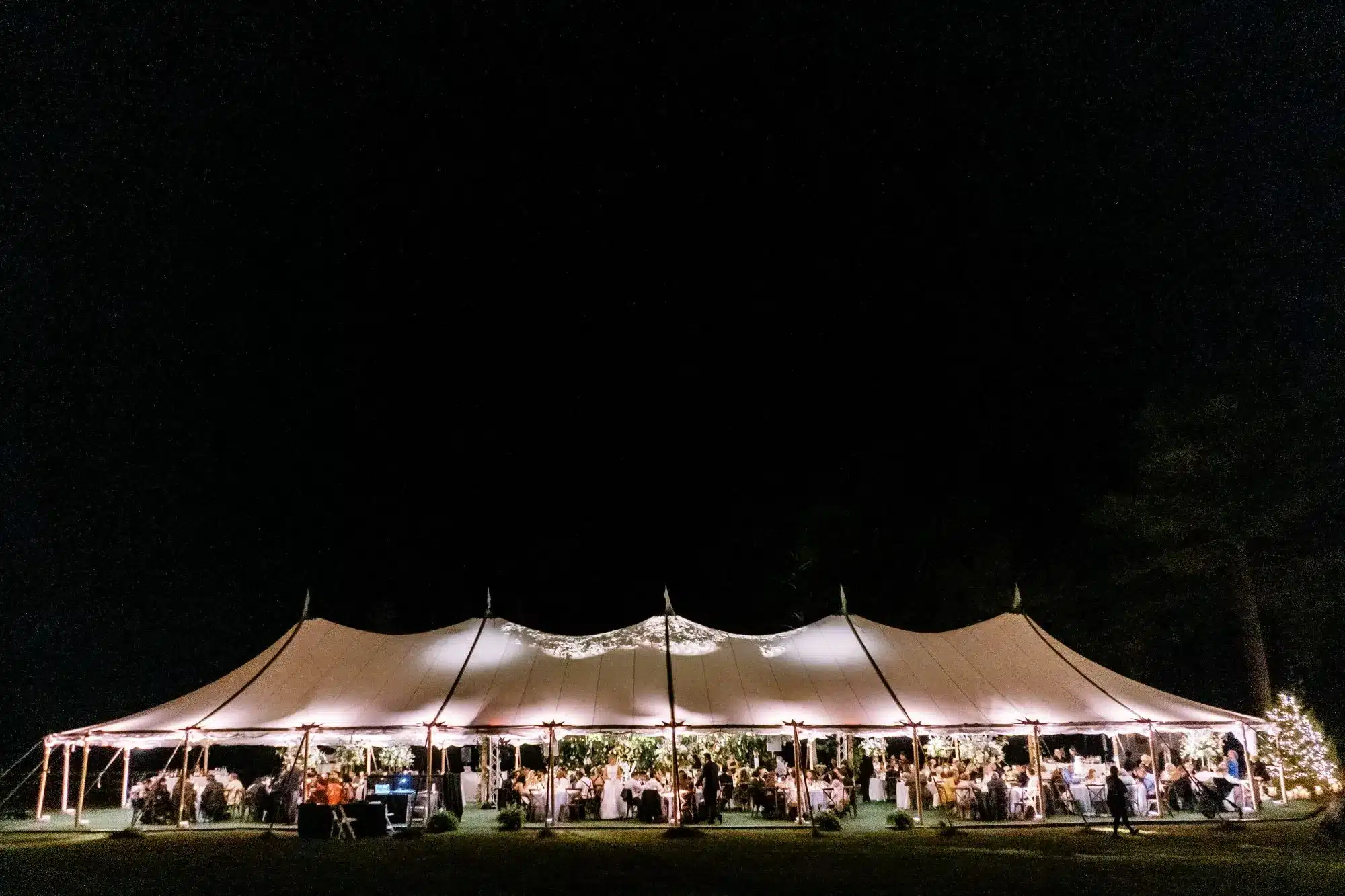 Evening view of a glowing event tent filled with guests celebrating New Year’s Eve in Raleigh.