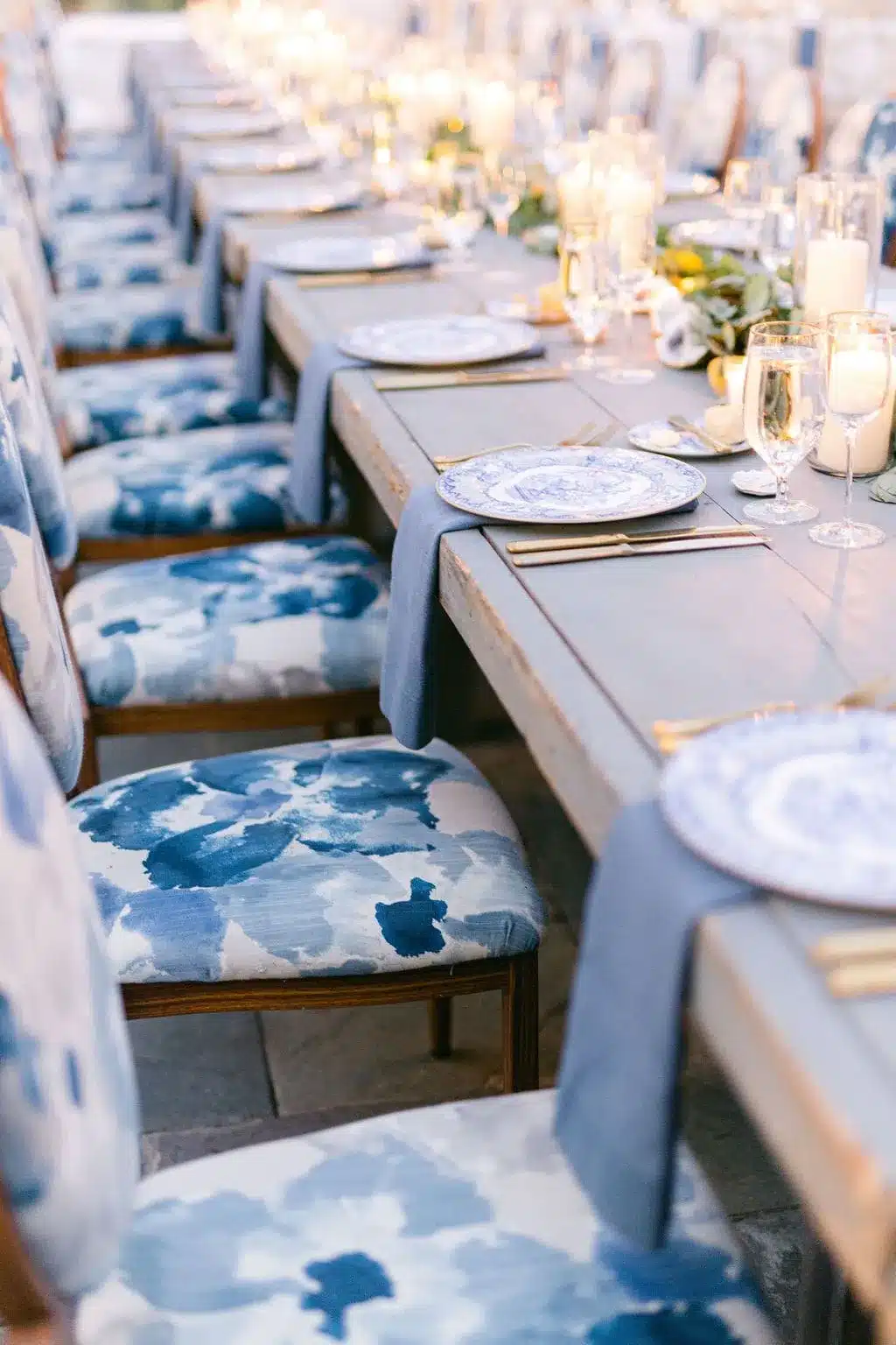 Long banquet table with blue-patterned china and coordinated linens.