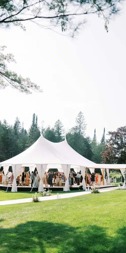 Large white event tent set on a green lawn for an outdoor corporate gathering.