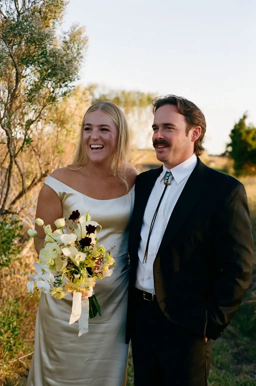 Bride and groom smiling together outdoors after the ceremony.