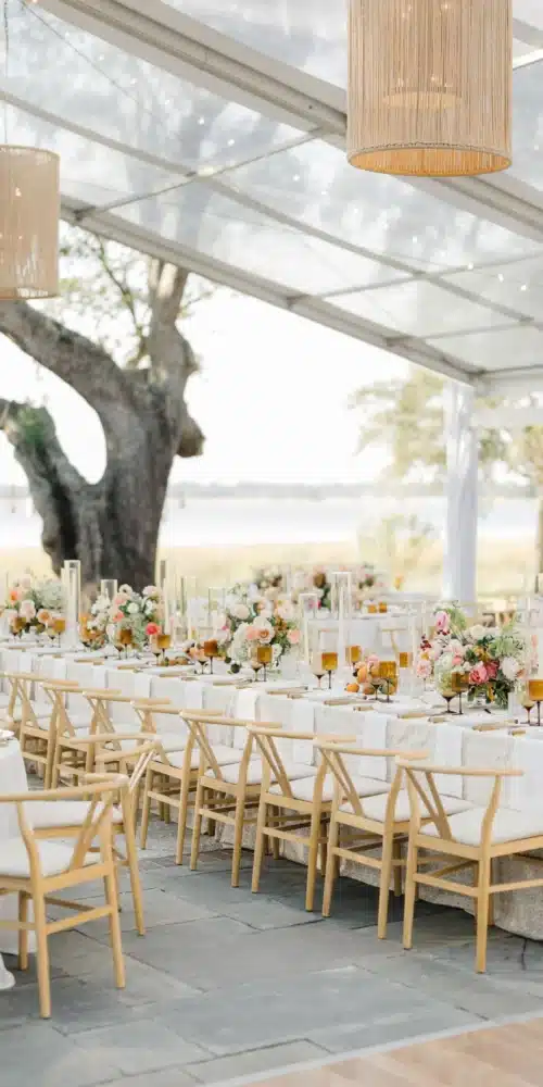 Chandeliers and string lights under tent at Charleston waterfront wedding