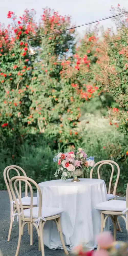 Bistro table with bentwood chairs and floral centerpiece in a garden