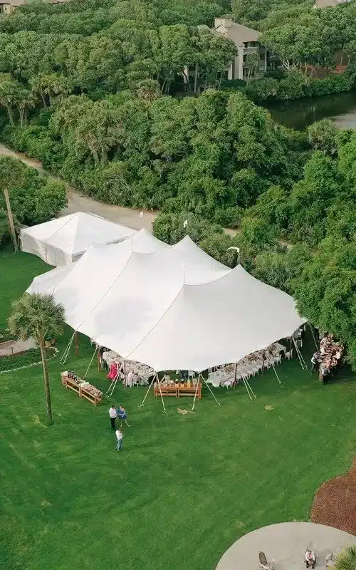 Aerial view of a sailcloth tent set on a lawn surrounded by greenery