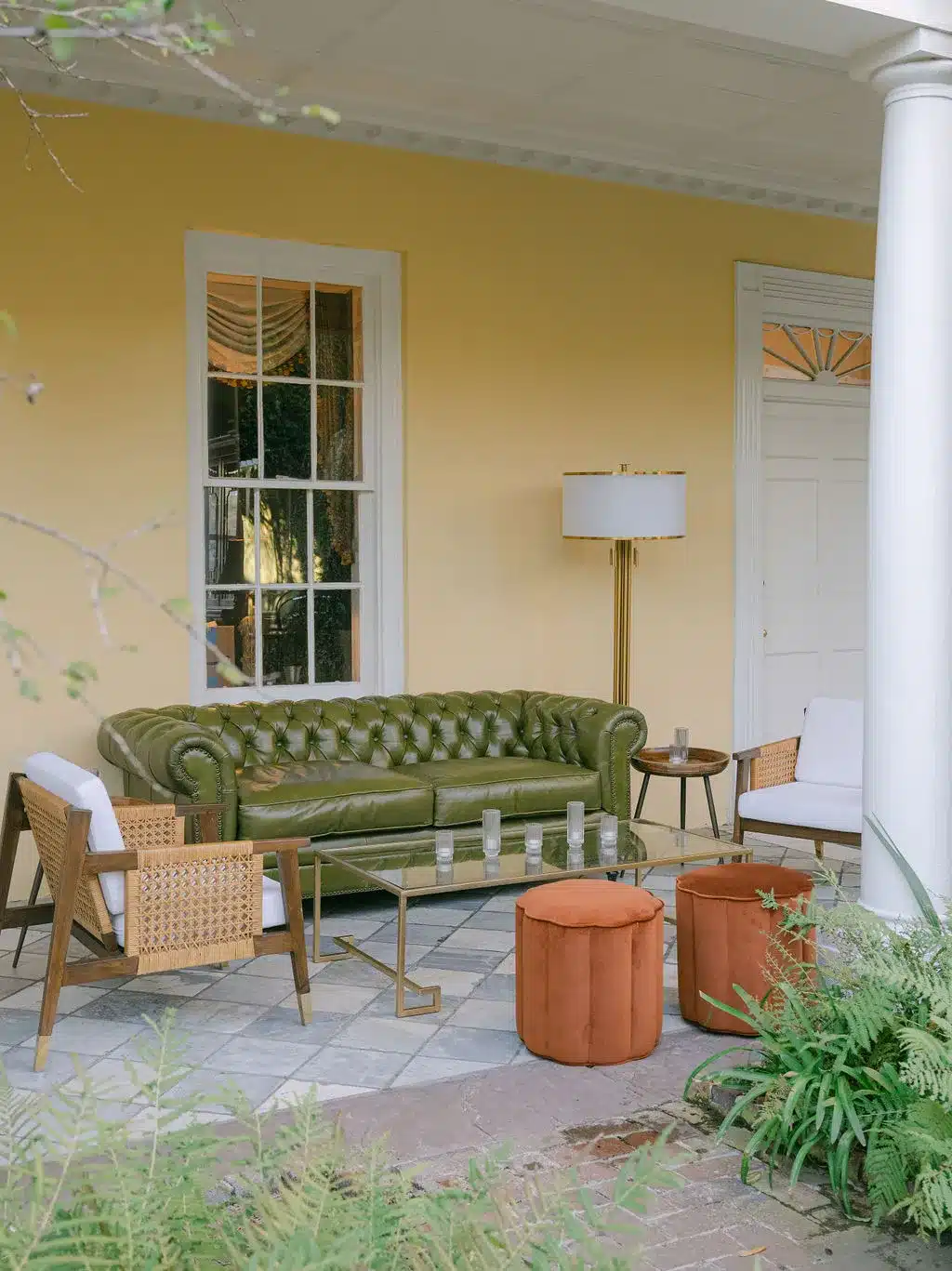 Styled patio lounge with green velvet sofa and modern seating at a Charleston venue.
