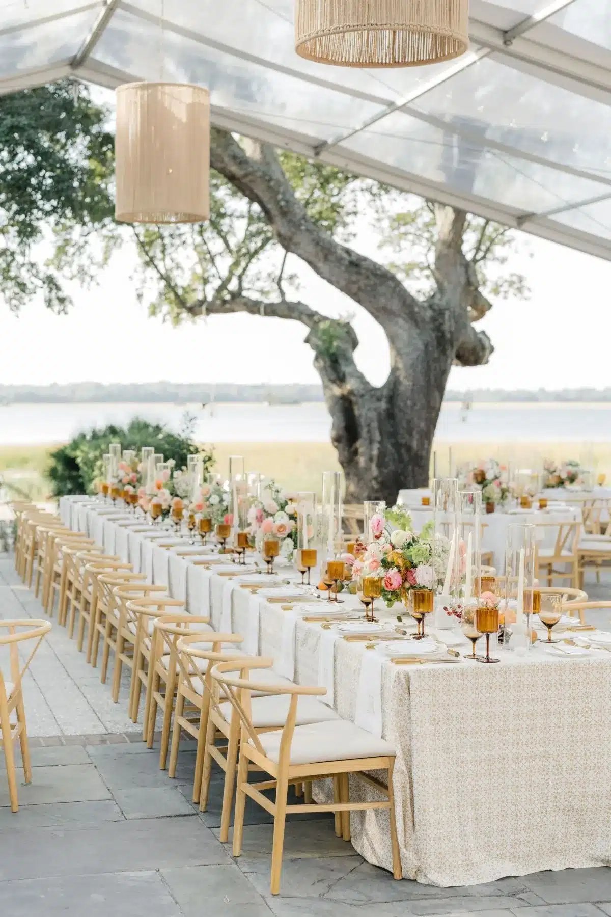 Long outdoor banquet table with patterned linens and pastel floral centerpieces.