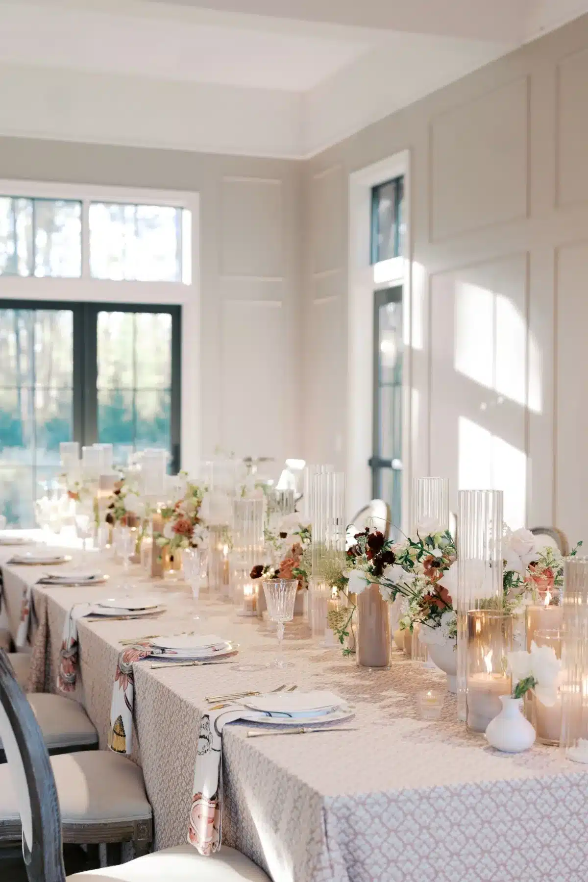 Elegant dining table set for an event in Nashville, featuring floral centerpieces, decorative glass vases, and soft candlelight, enhancing the ambiance for gatherings.