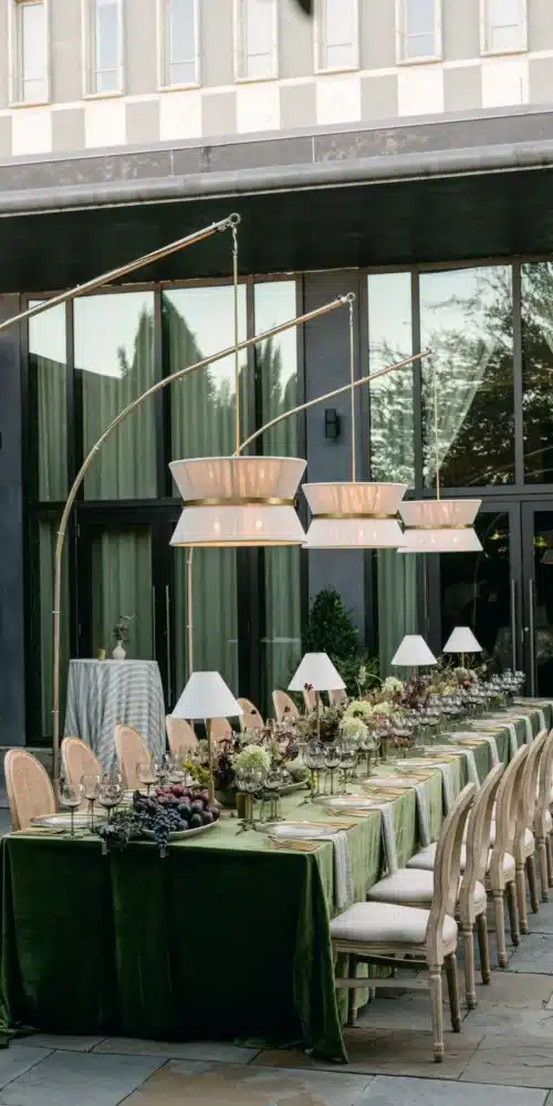 a dinning table setup with handing lights on the rooftop