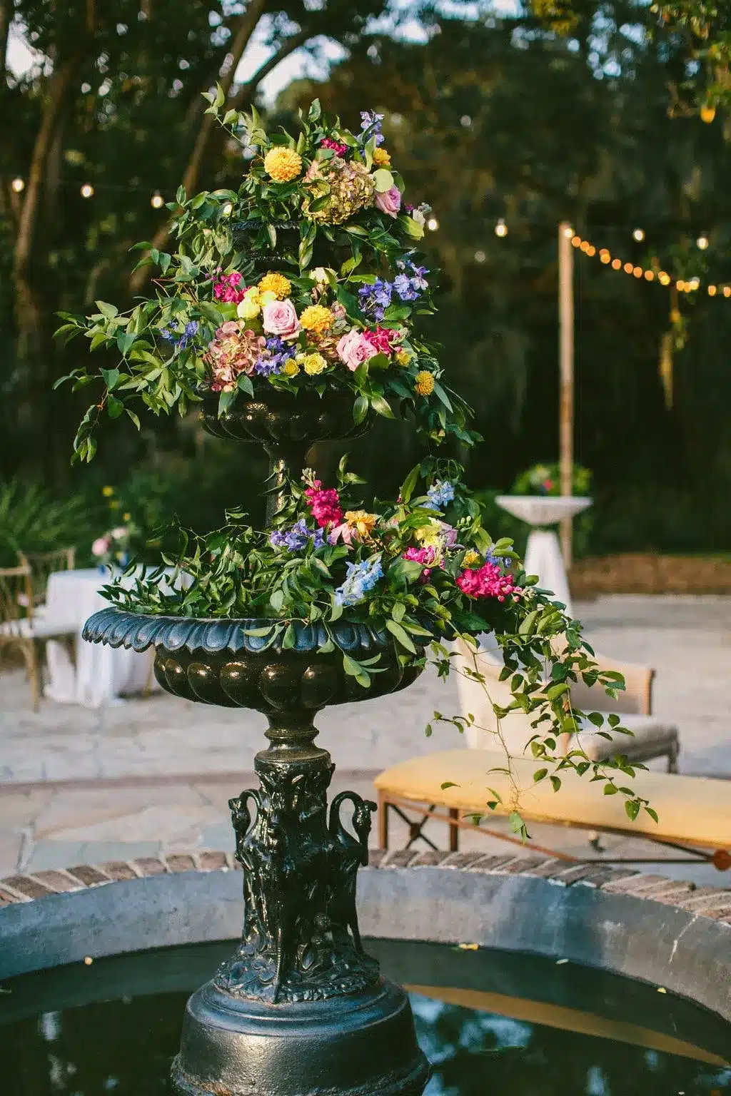 Floral arrangement in a decorative fountain, featuring vibrant flowers and greenery, enhancing outdoor event aesthetics for spring garden parties.