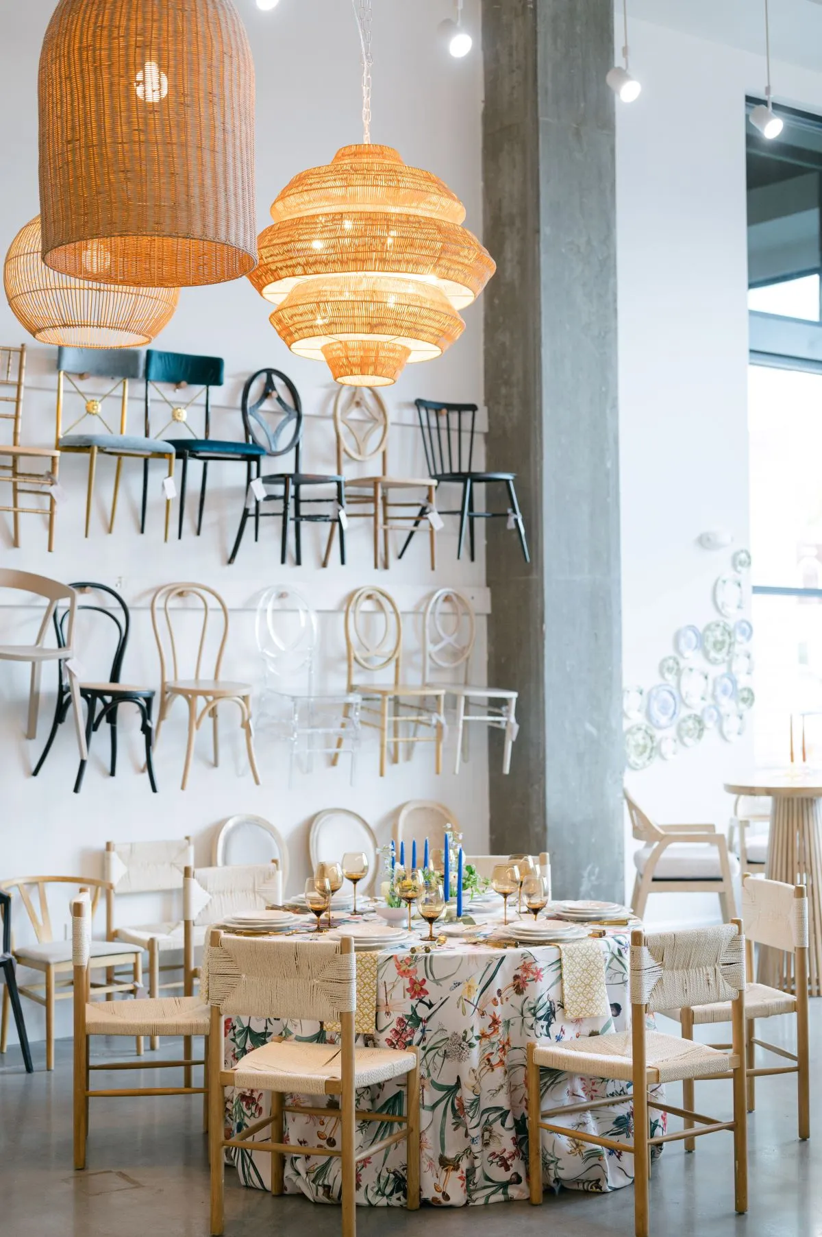 Event showroom with hanging woven pendant lights and displayed chairs on wall