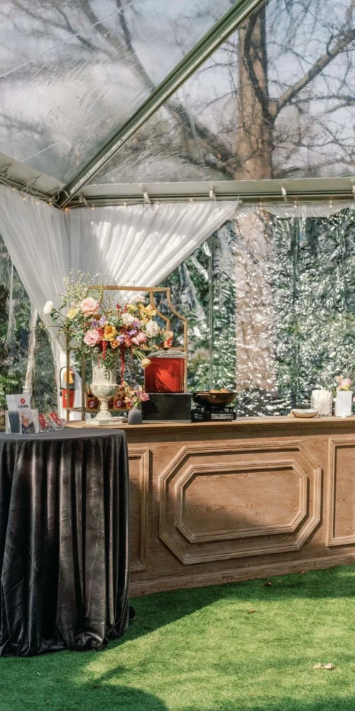 Clear tent catering station with side draping for shaded service area