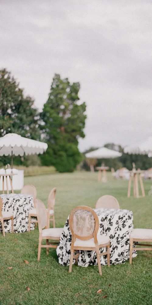 Casual outdoor seating area with patterned linens and umbrellas for a relaxed event lounge