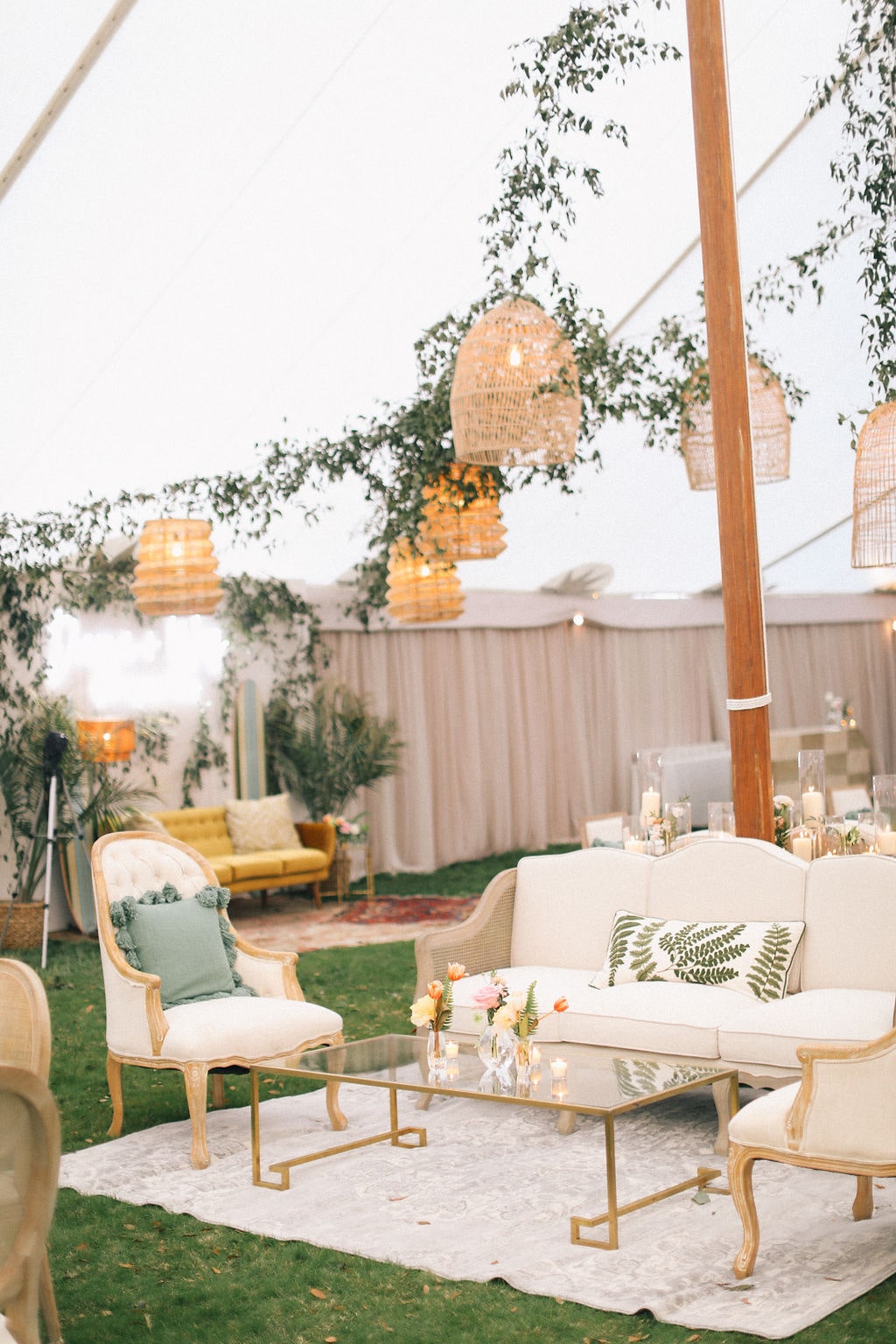 Close-up of woven pendant lights and greenery draped inside a sailcloth tent