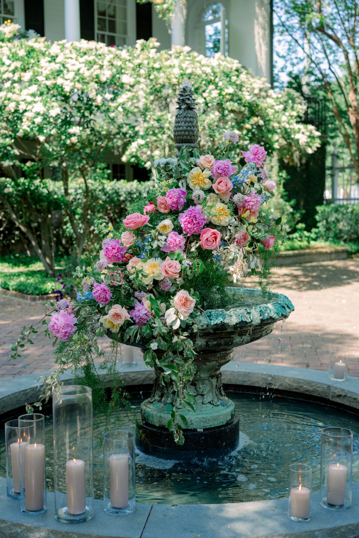 Floral arrangement on fountain with candles for summer event rentals in Raleigh, NC