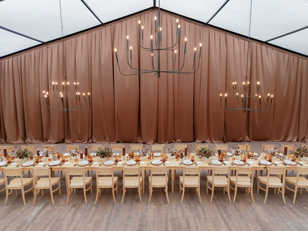 elegant wedding long table draped backdrop chandeliers