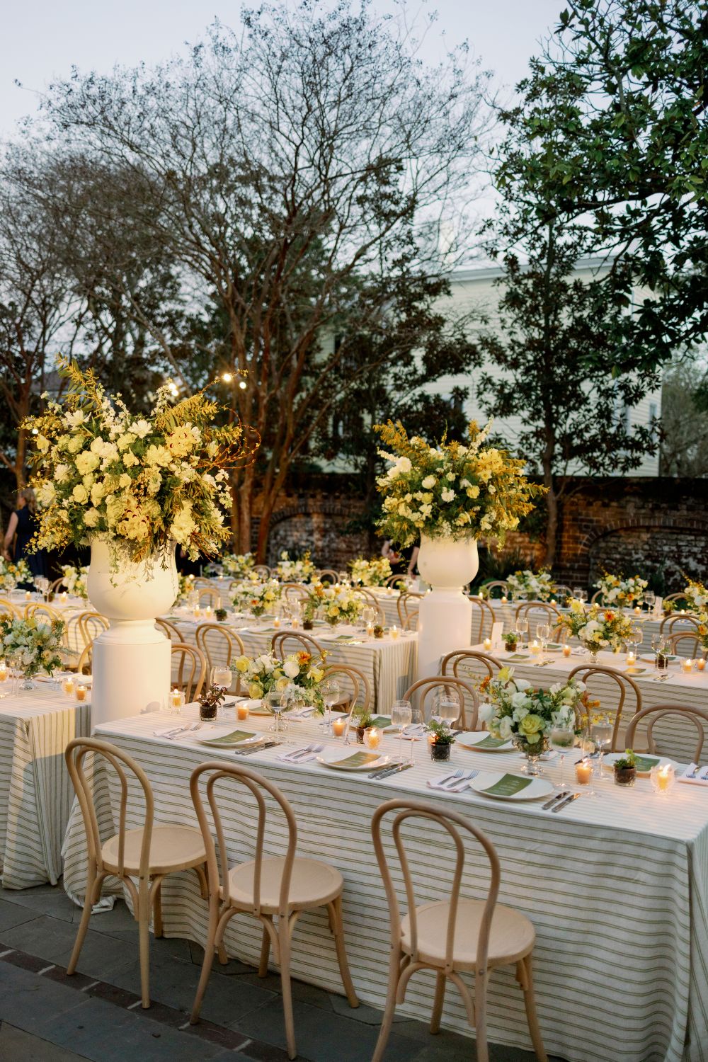Elegant outdoor event tablescape with floral arrangements and chair rentals for summer gatherings in Raleigh, NC.