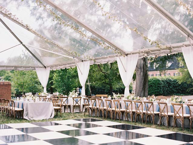 Clear tent with checkered dance floor and reception seating