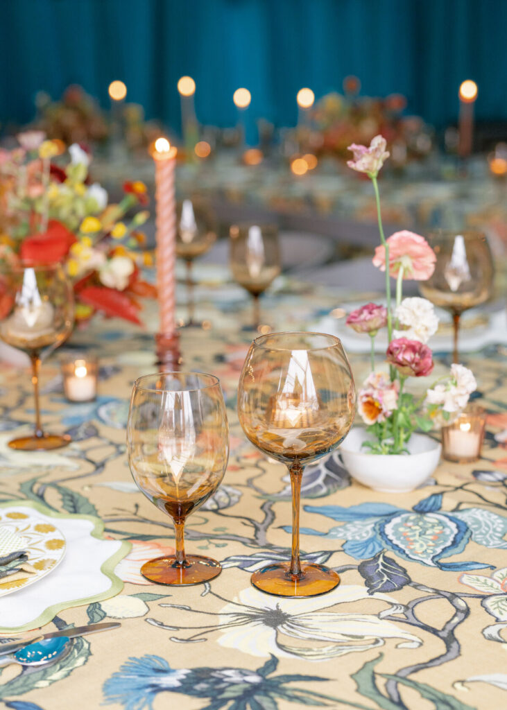 reception table decor with colored glassware and flowers
