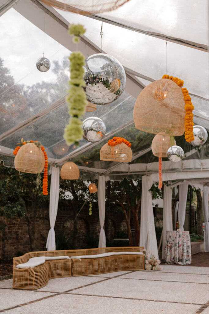 wedding tent ceiling decor with disco balls and floral installations
