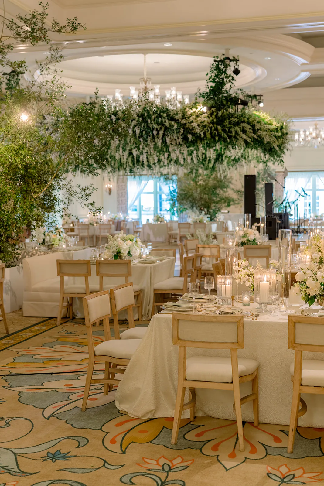 Elegant reception tables beneath a suspended floral installation