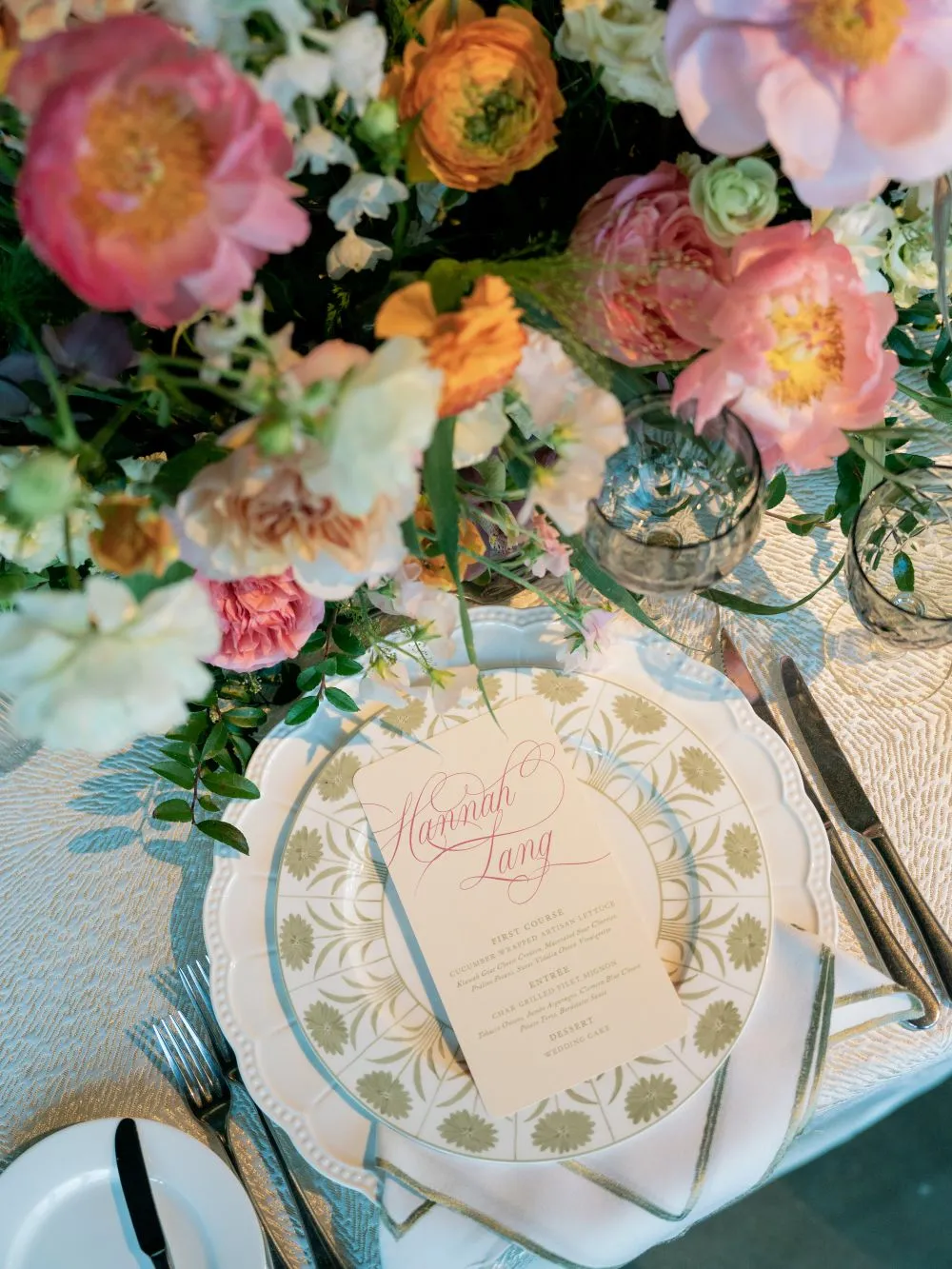 Patterned wedding place setting with a menu and colorful floral arrangement | Curated Events Patterned wedding place setting with a menu and colorful floral arrangement