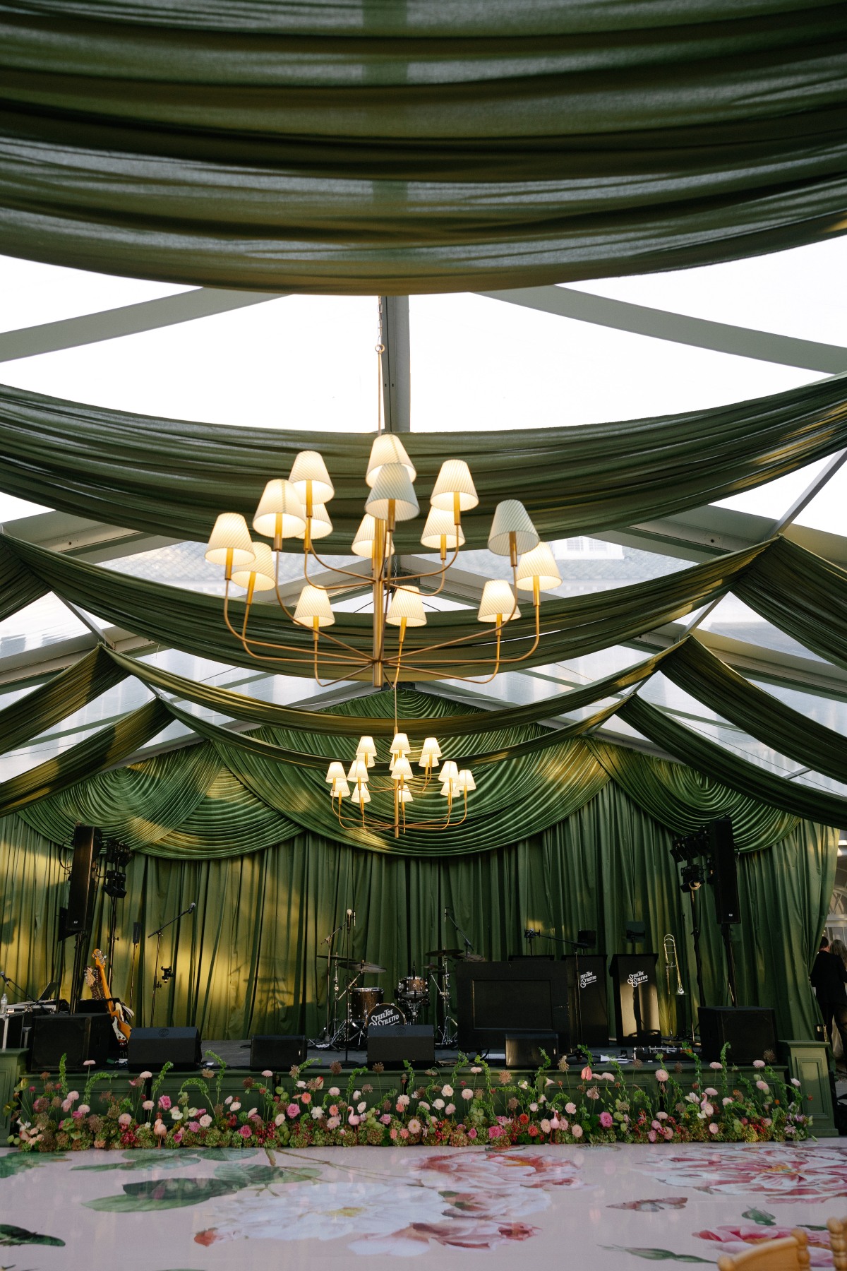 Green draped summer event space with chandeliers, floral tables, and formal rental seating | Curated Events Green draped summer event space with chandeliers, floral tables, and formal rental seating