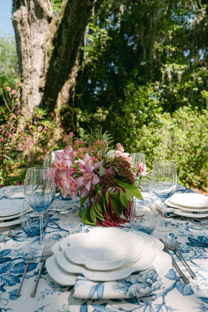 Elegant outdoor dining setup with floral centerpiece and tableware.