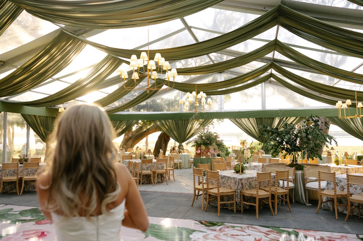 Guest overlooking a tented Chesapeake summer event with draping, lighting, and rental seating | Curated Events Guest overlooking a tented Chesapeake summer event with draping, lighting, and rental seating