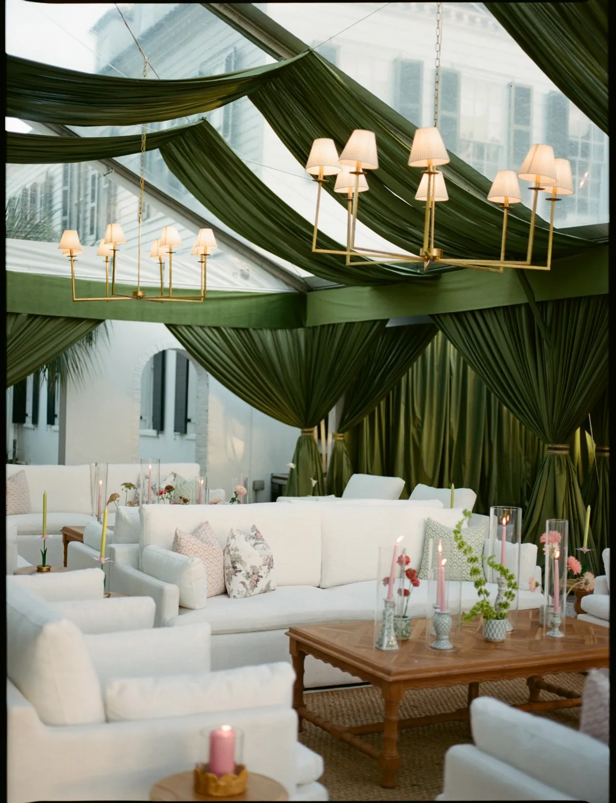 White lounge seating beneath dark green tent draping