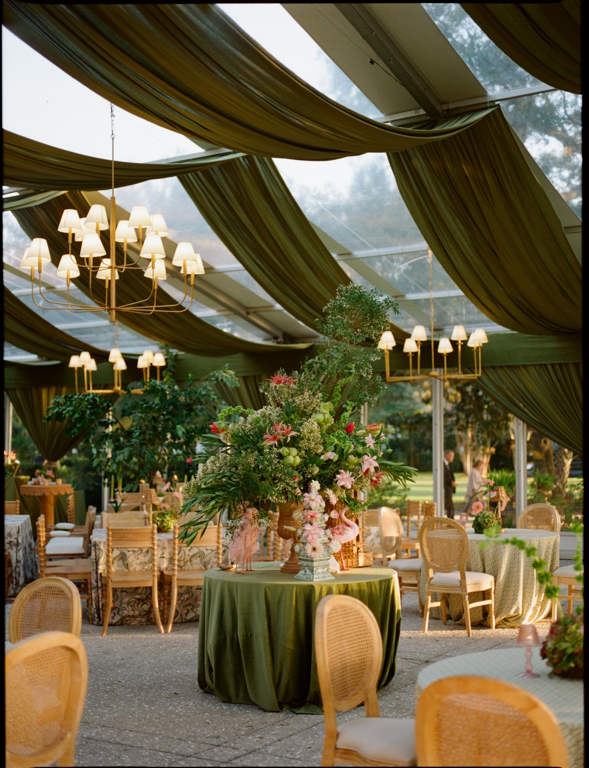 Outdoor Chesapeake reception with green draping, chandeliers, and floral table rentals | Curated Events Outdoor Chesapeake reception with green draping, chandeliers, and floral table rentals
