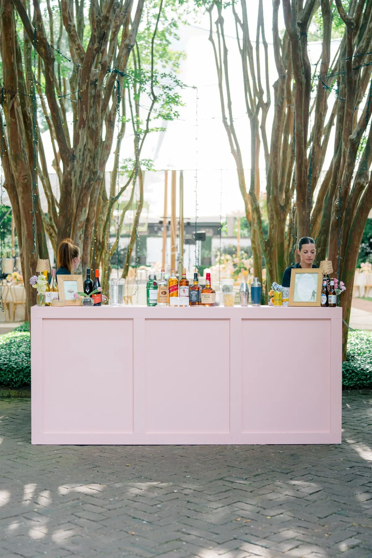 Outdoor pink event bar set beneath mature trees