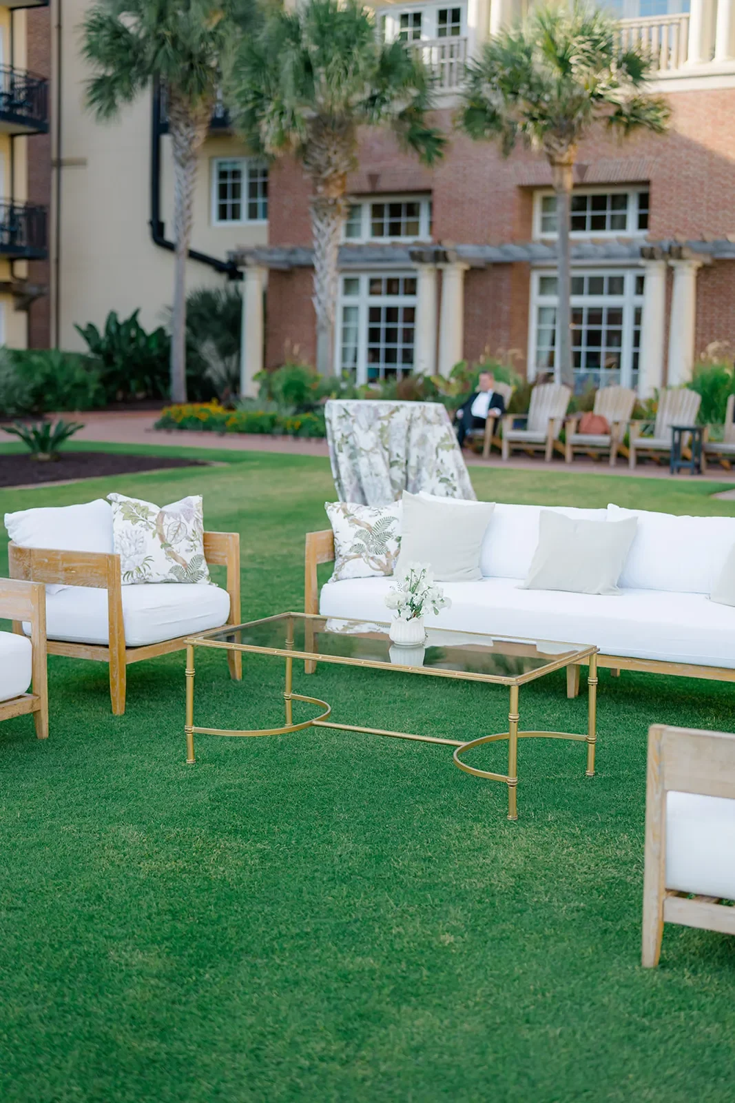 Cane sofa and chairs with a glass coffee table in a draped wedding reception lounge