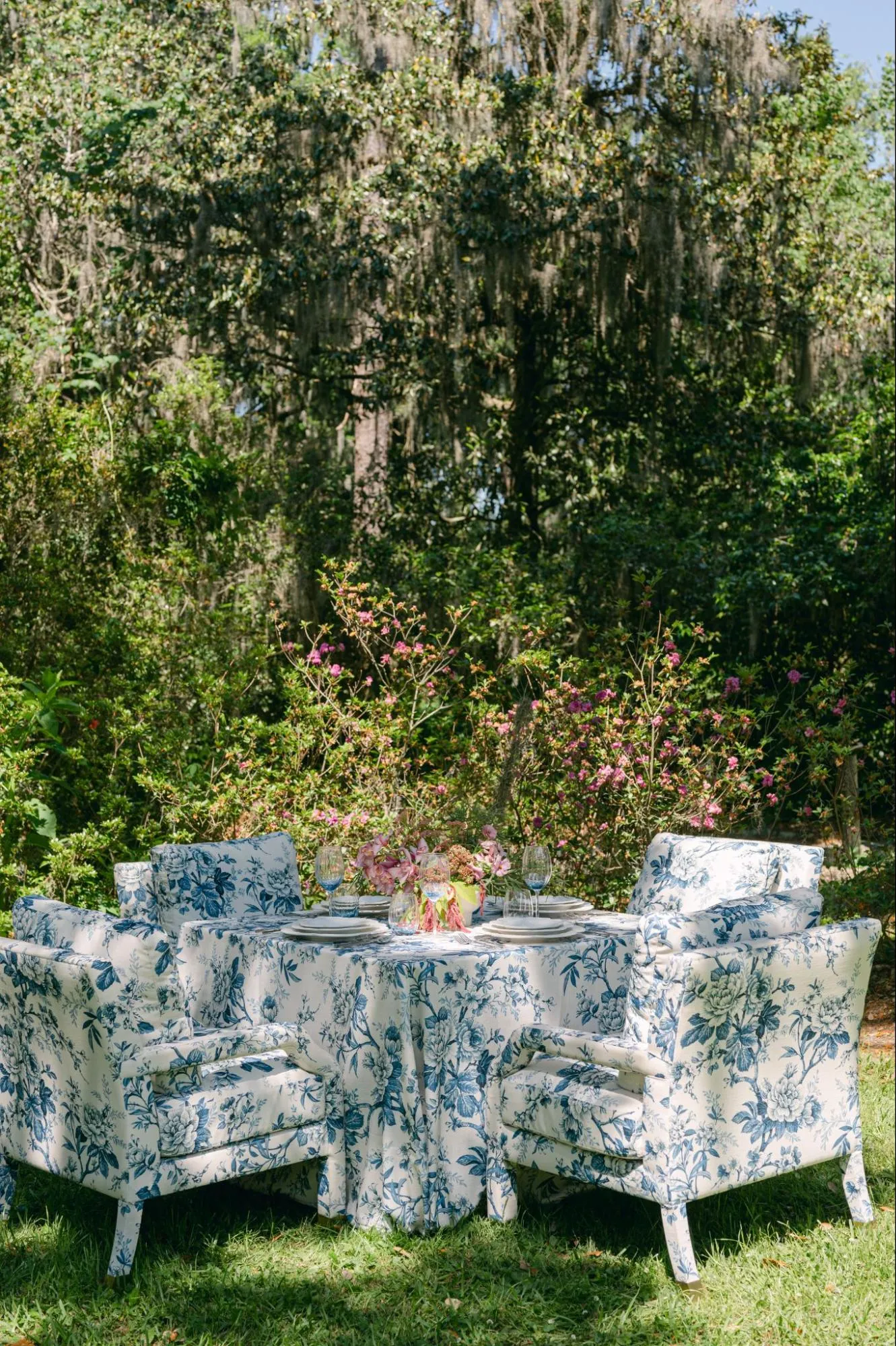 Round outdoor table with blue-and-white floral linen and matching upholstered chairs | Curated Events Round outdoor table with blue-and-white floral linen and matching upholstered chairs