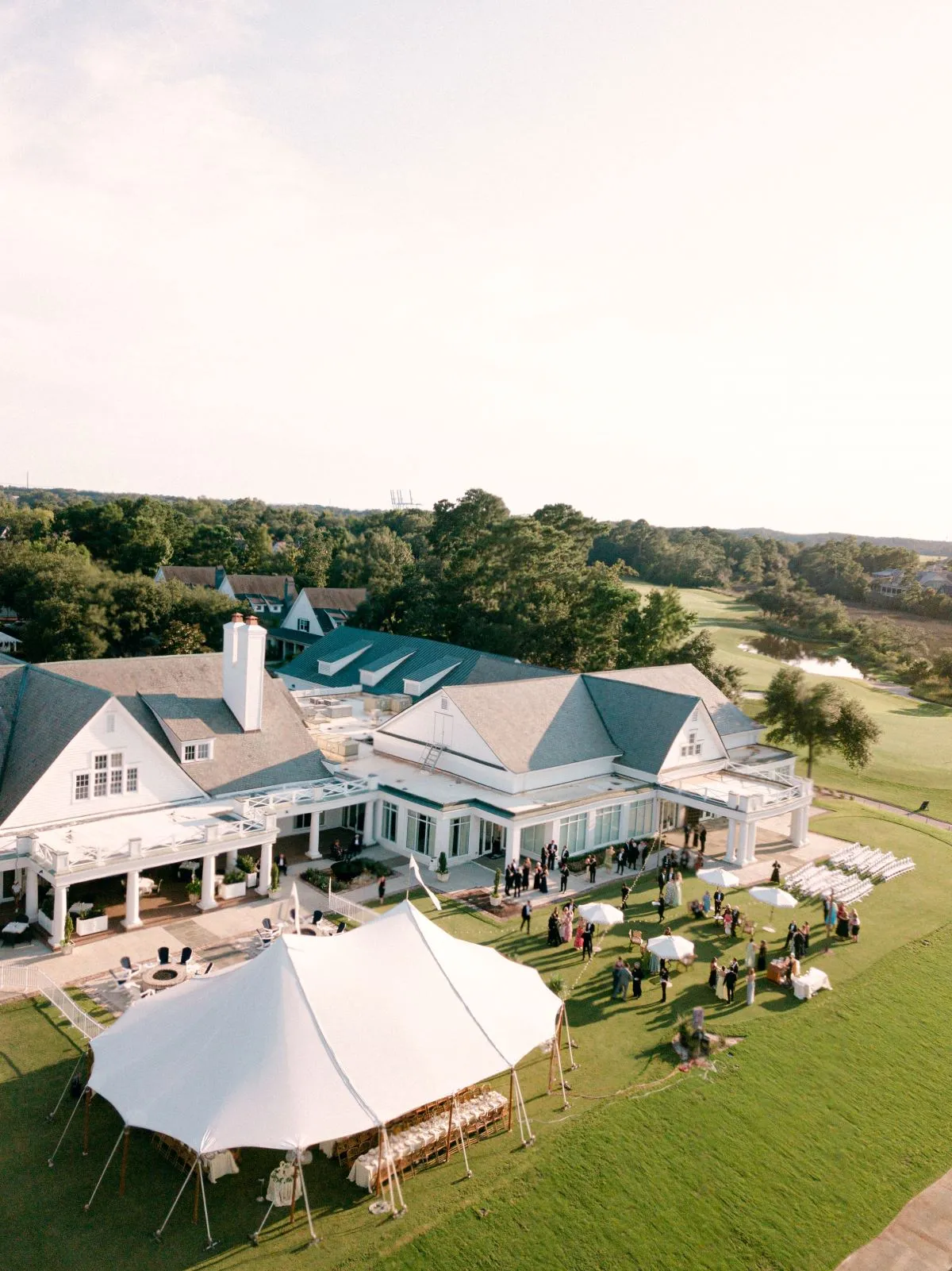 Aerial view of a sailcloth event tent on a large lawn beside an estate