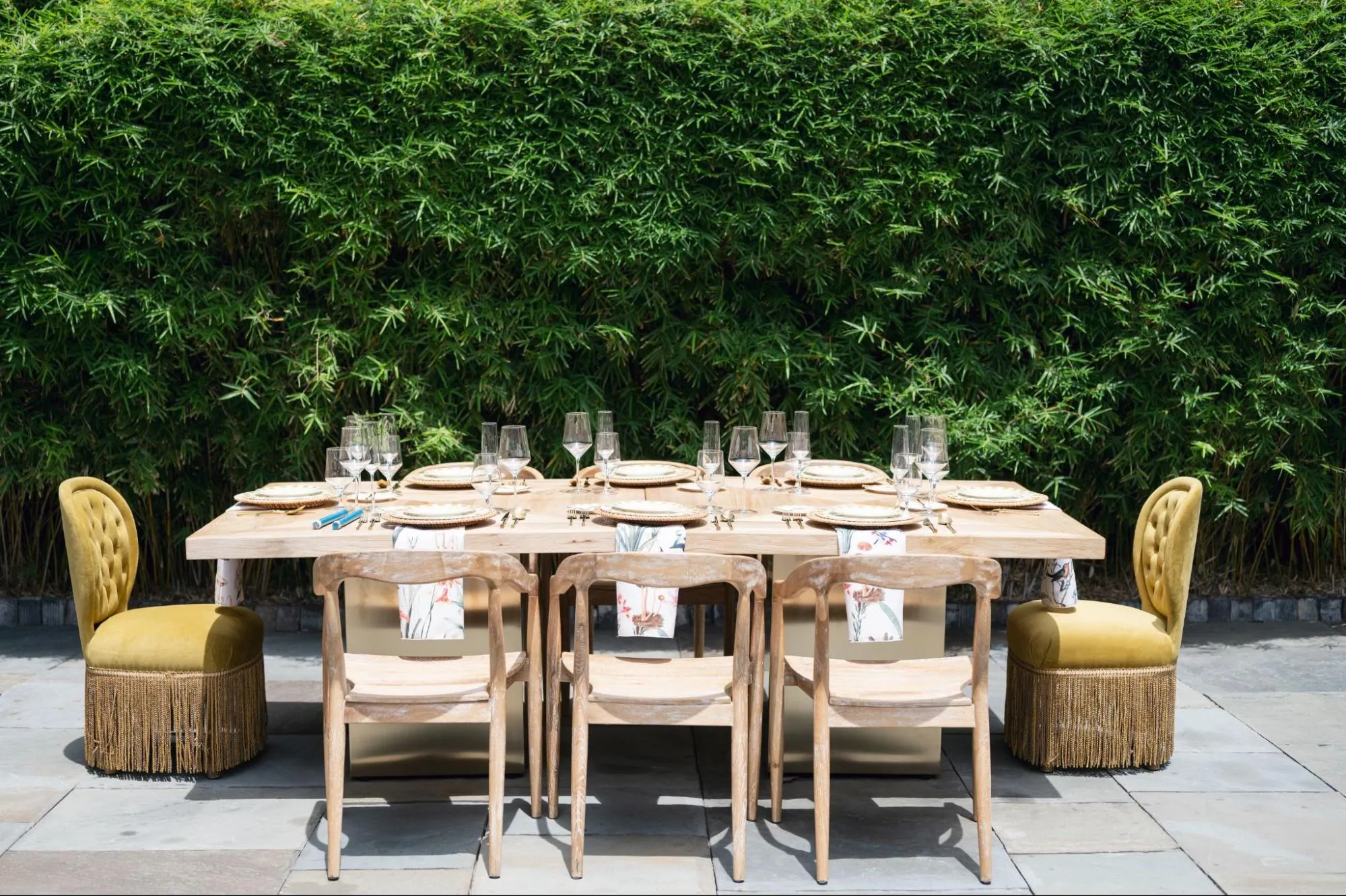 Outdoor dining table with natural wood finishes, neutral chairs, and warm fall accents